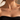 Woman in a black top wearing the dainty gold Demi Heart Necklace with a green and clear heart