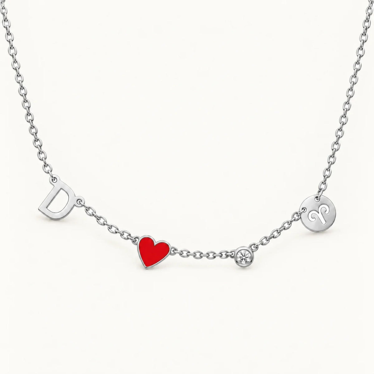 Silver Fable Necklace with a D initial, red heart, clear birthstone and Aries sign charm
